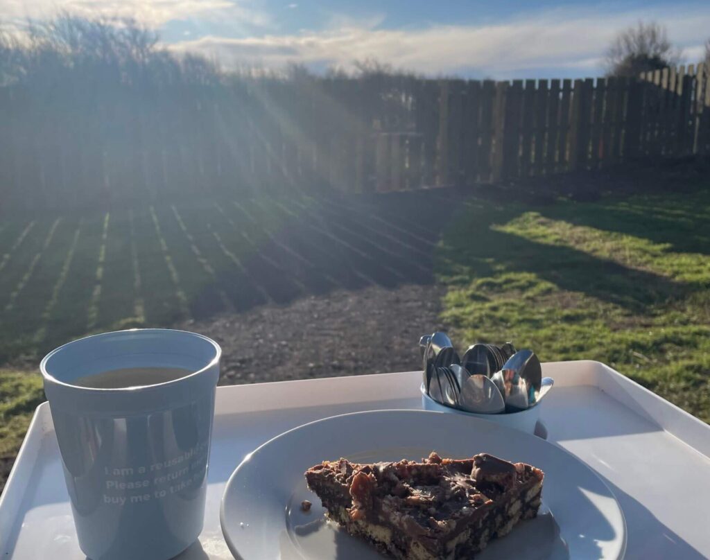 Enjoying a nice hot drink and slice of cake in the sun at Nicsnax